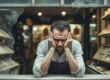 Imagem de um pequeno empresário ou lojista, com expressão de frustração, analisando uma vitrine de loja empoeirada, representando o Efeito “Vitrine Desatualizada” no mundo digital e como a falta de otimização de sites ou landing pages prejudica o desempenho e o retorno sobre o investimento (ROI) de anúncios pagos no Google Ads e Meta Ads.